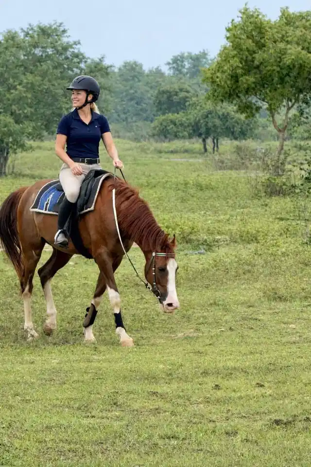 Rider moving calmly through green country at Vonfidel Ranch in Sri Lanka