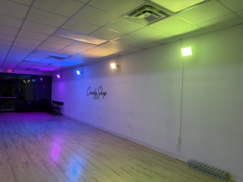 Side view of the CandyShop Dance studio with logo wall and open floor