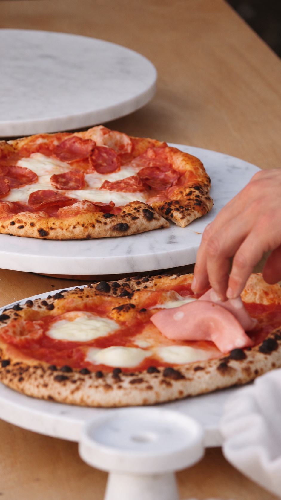 Adding the finishing toppings to fresh pizza