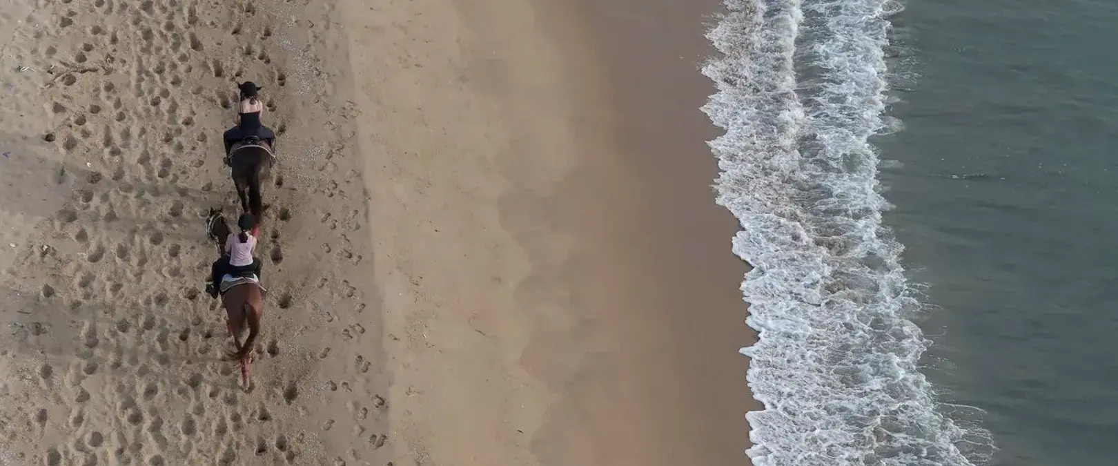 Two riders on the shore near Punanai, seen from above.