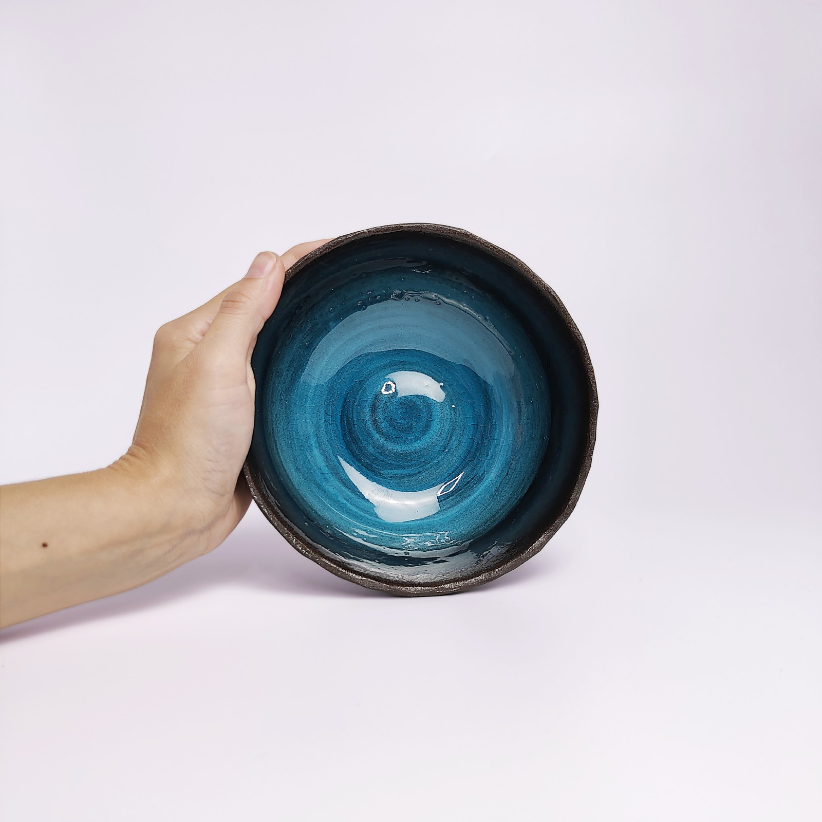 unique handmade ceramic bowl with dark clay exterior and vibrant deep blue glaze, artistic decorative tableware