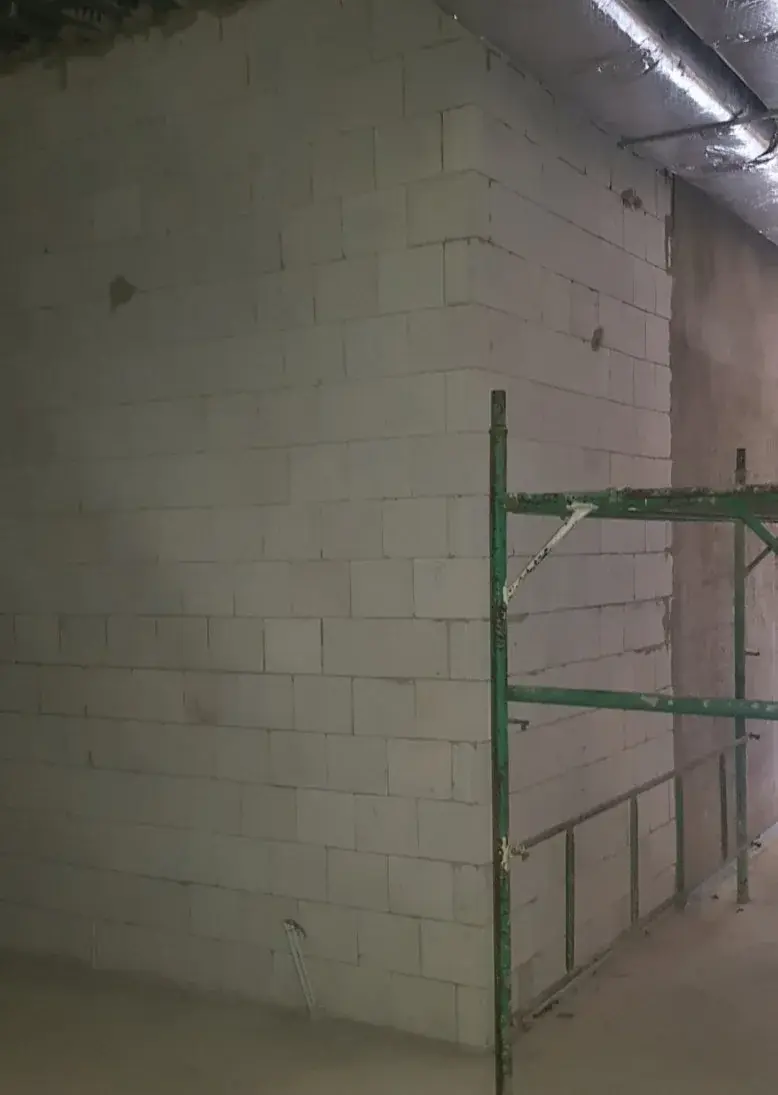 The final selected view shows full-height masonry before finishes, with site access equipment still in place.