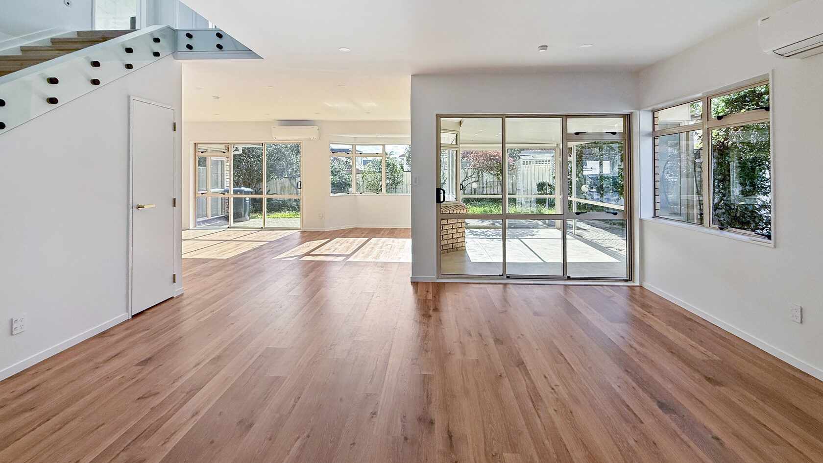 Spacious St Heliers living area with new timber flooring and large windows.