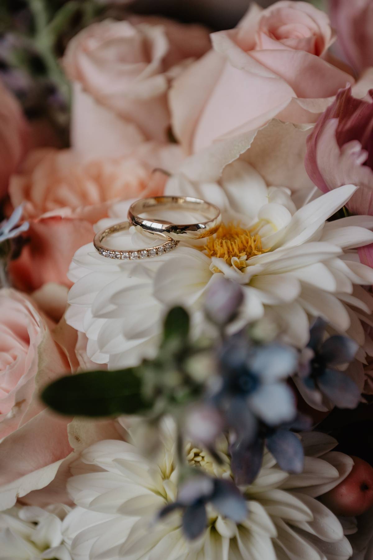 Wedding rings on bouquet flowers, close-up detail for a mountain wedding in Austria