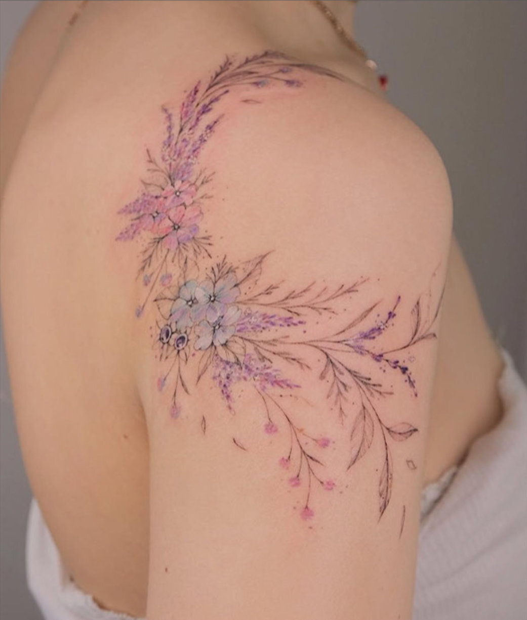 Blüten in sanften Farben, Floral-Tattoo von Cathy im INTO Tattoo Studio in Wien.