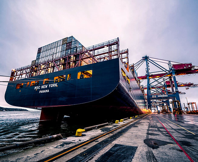 Large container vessel alongside a port terminal at dusk