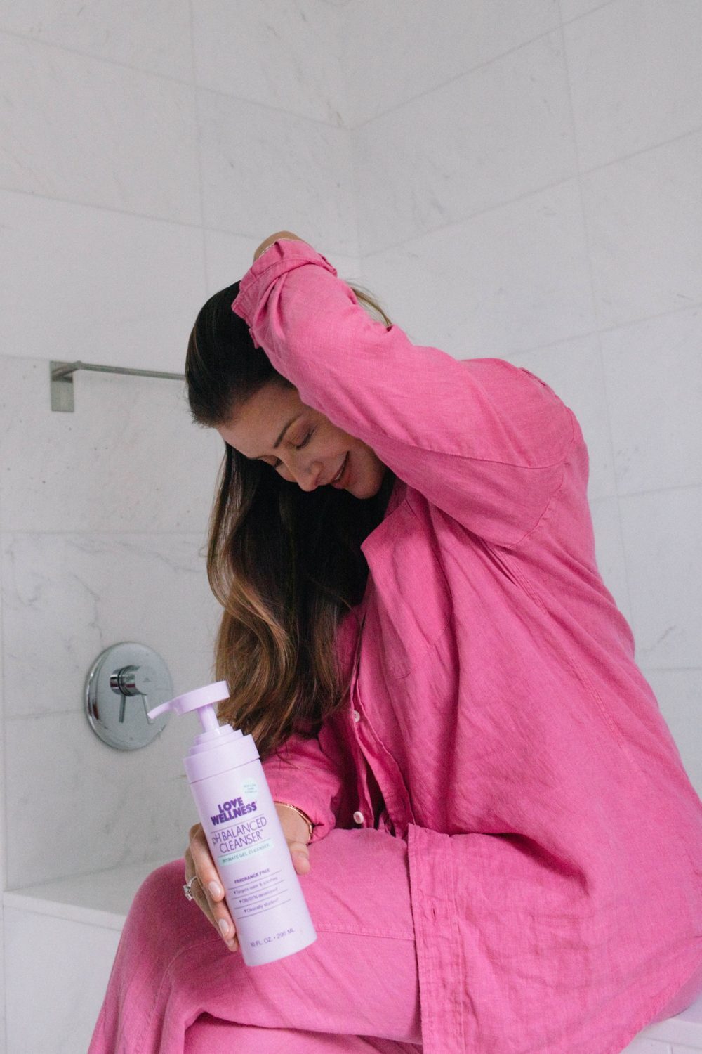 Lo in pink, laughing, holding pH Balanced Cleanser