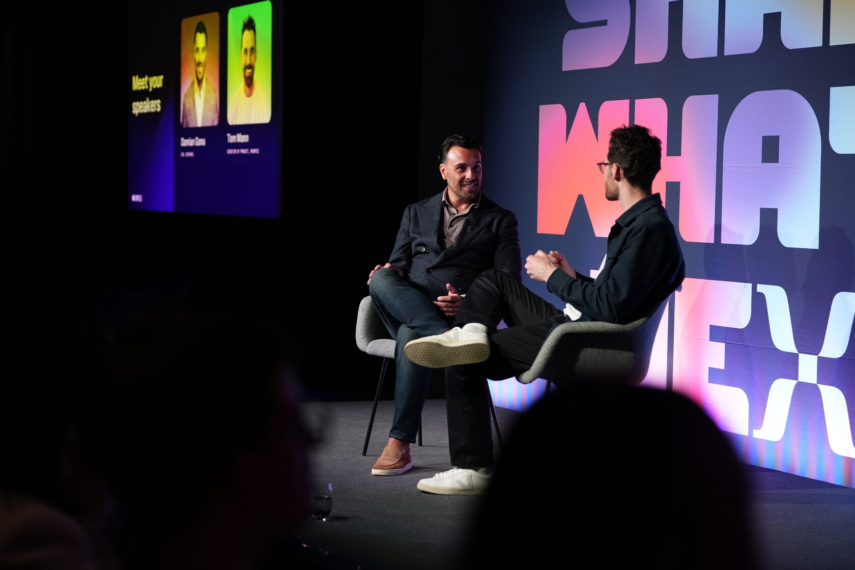 Two speakers in conversation on a conference stage