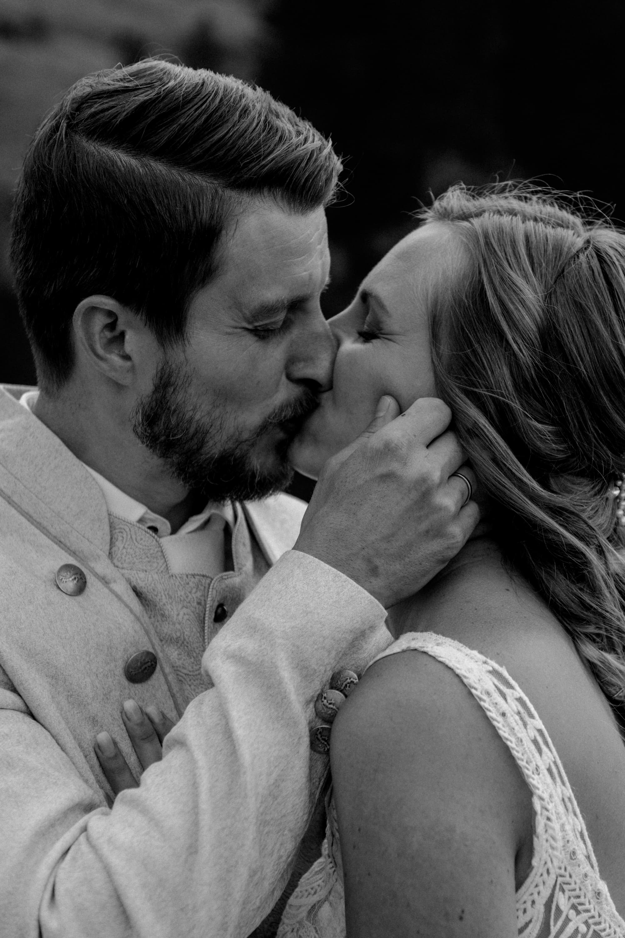 Black-and-white close-up of a couple kissing, intimate wedding portrait