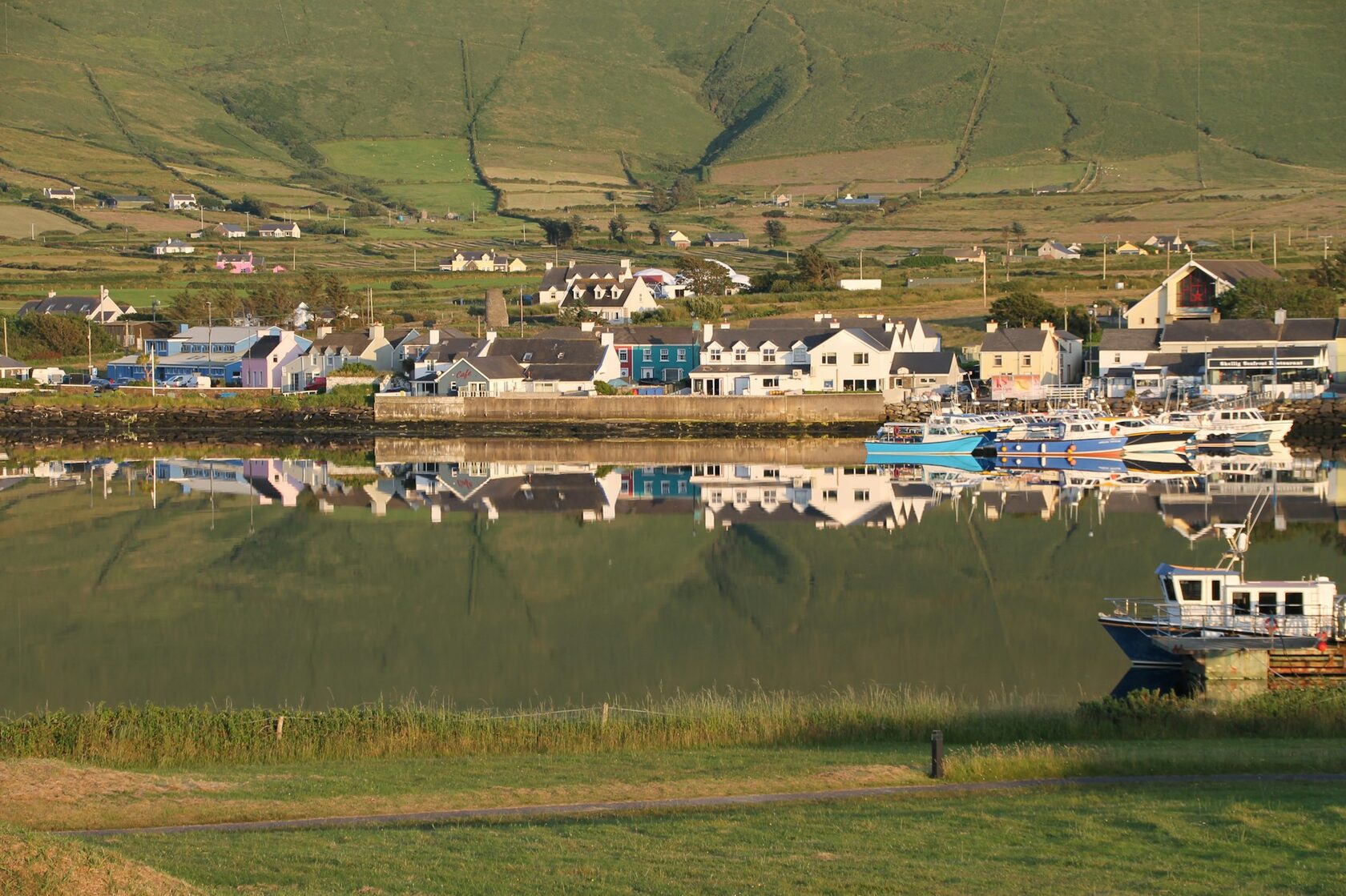 Colorful houses of Portmagee reflected in the harbor, County Kerry