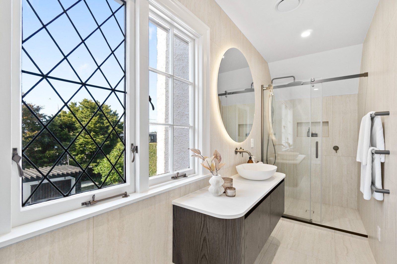 Modernised Owens Road bathroom with curved mirror, floating vanity and walk-in shower