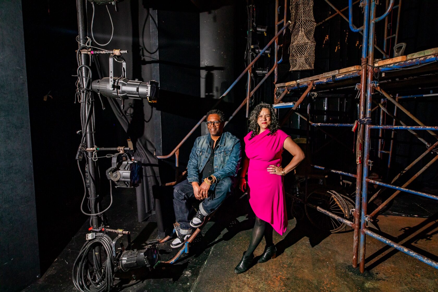 Lindsay Smiling and Leigh Goldenberg backstage among scaffolding and stage lights