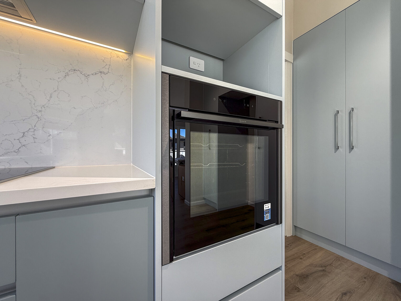 Built-in kitchen appliances and pale cabinetry in the Hollywood Avenue renovation