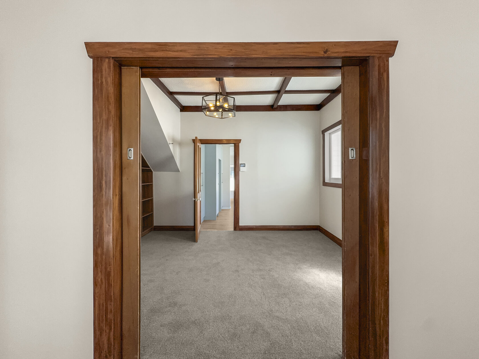 Timber-framed opening into a carpeted room in the Hollywood Avenue Epsom bungalow