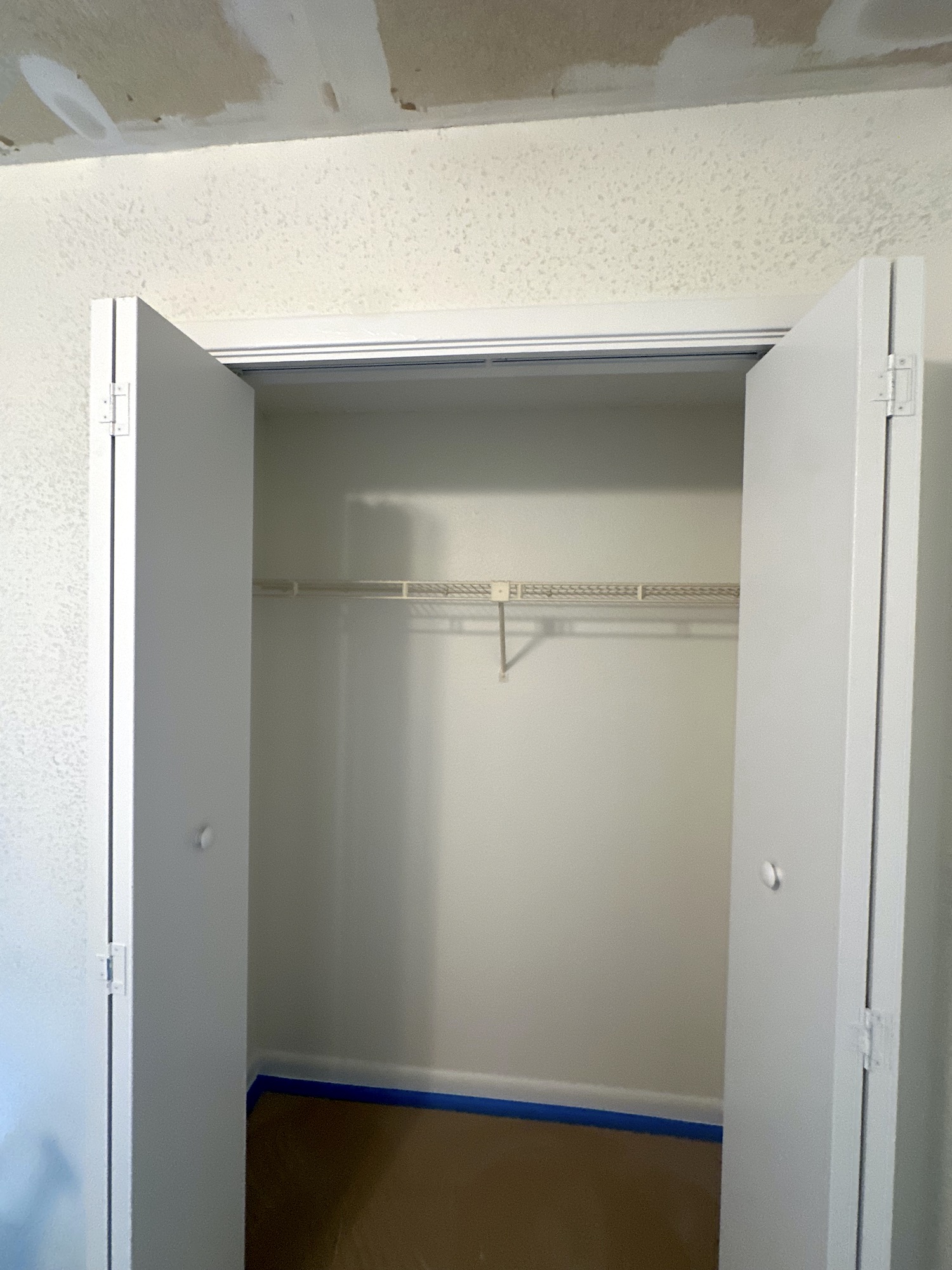 Existing bedroom closet before the new storage organizer was installed