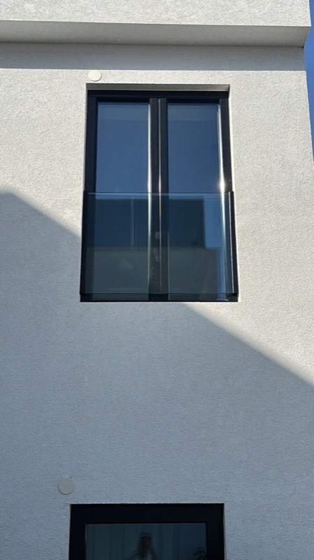 Balcón francés con barandilla de cristal instalada en fachada de vivienda de la Costa del Sol