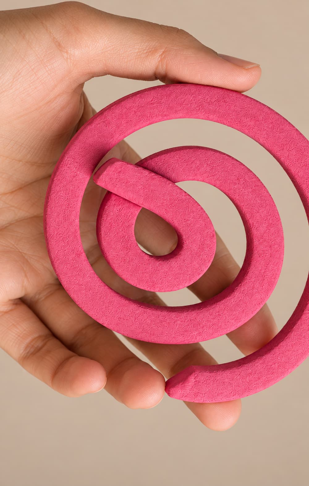 Pink mosquito coil held in a hand