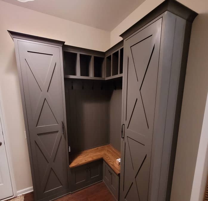Diagonal view of farm house style mudroom cabinets with built-in bench in dark grey color