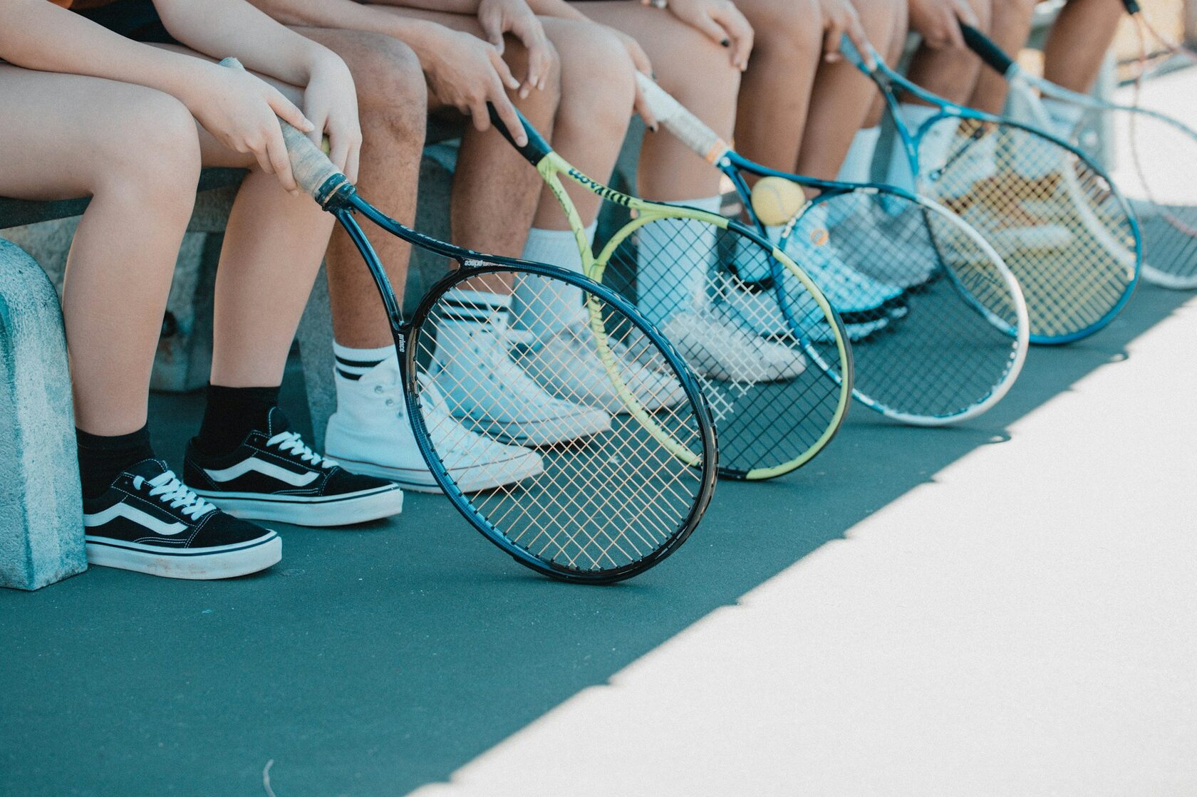 Adult tennis students laughing together after a clinic