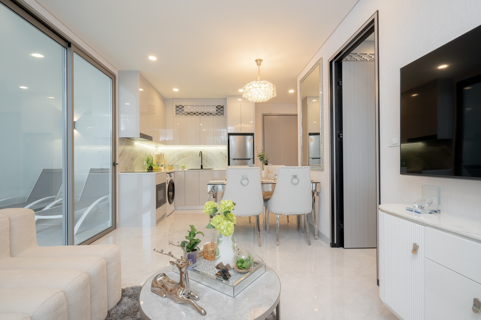 Living room, kitchen and balcony doors in the Copacabana Coral Reef show unit