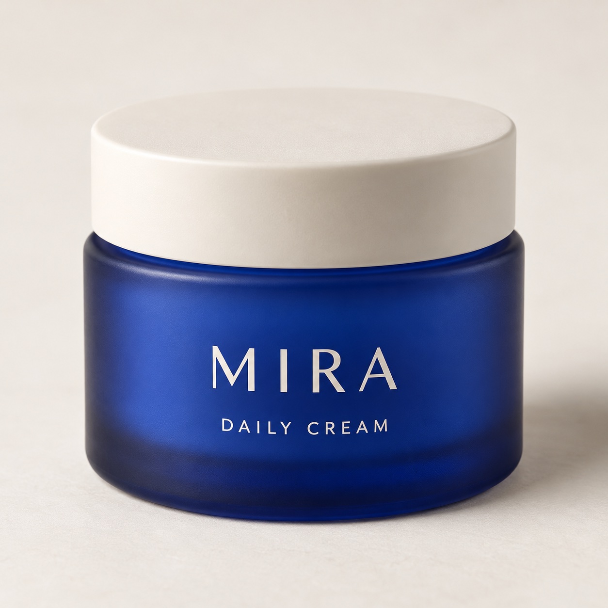 Fictional MIRA blue glass skincare jar with a cream lid and front label.