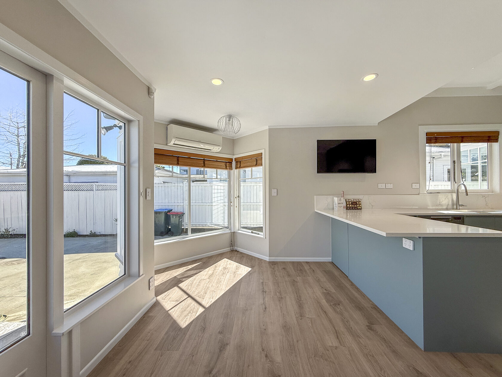 Renovated kitchen opening into a bright living space with large windows