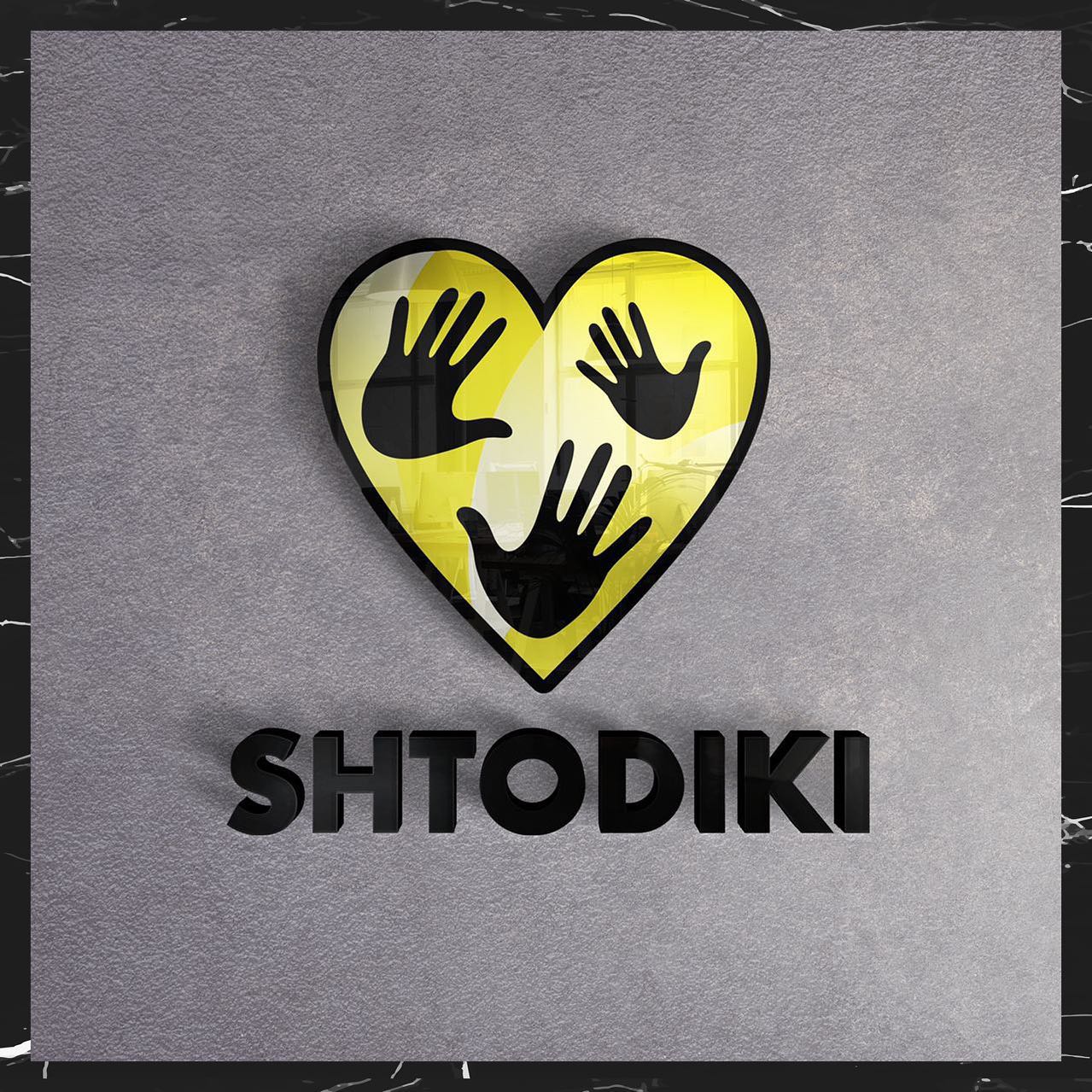 SHTODIKI kids clothing store logo – a yellow heart with handprints