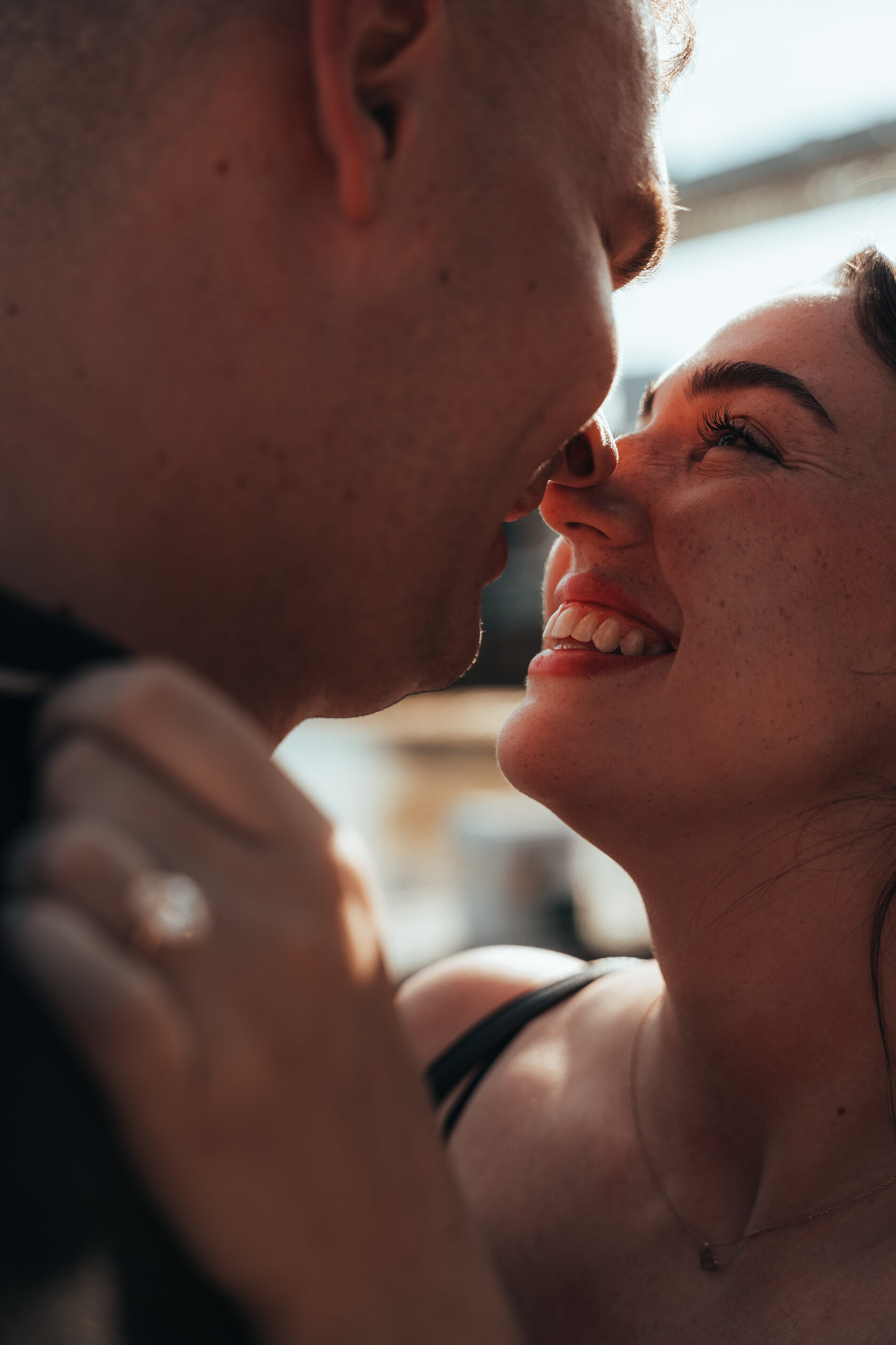 An intimate close-up of a smiling couple leaning towards one another