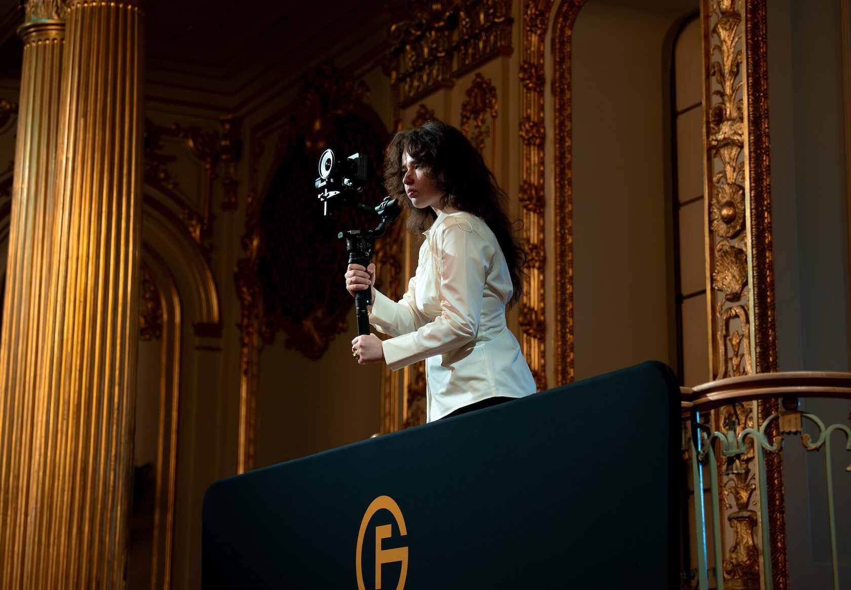 A We Stream operator filming from a balcony at a gilded London venue