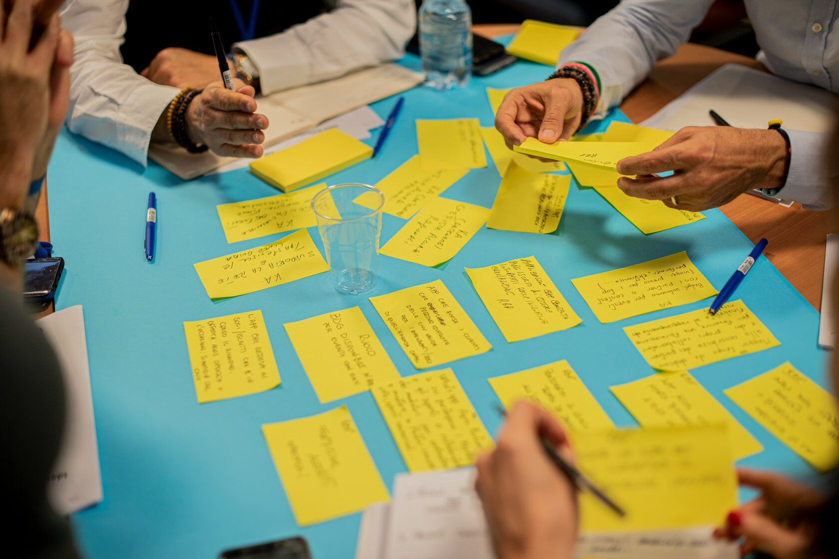 A CWM participant writing in a notebook during a workshop, head bent, mid-sentence.