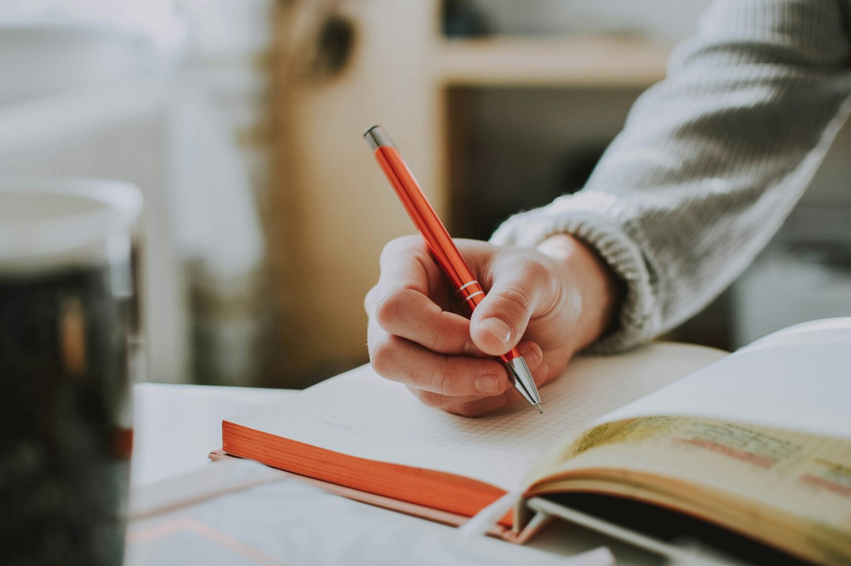 Persona escribiendo y desarrollando sus ideas en un cuaderno
