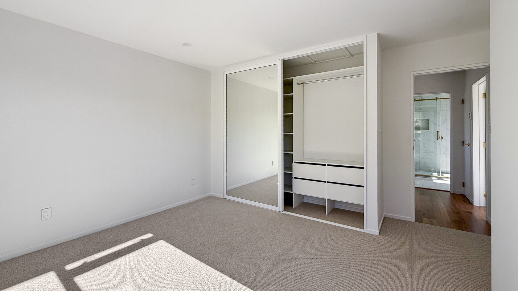 St Heliers bedroom with mirrored wardrobe doors and access to an ensuite bathroom.