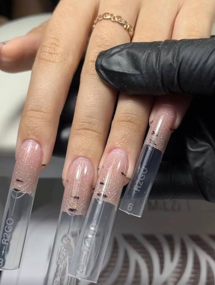 Yuliya's real work: nude pink glitter hard gel with transparent Dual Forms placed on a client's nails