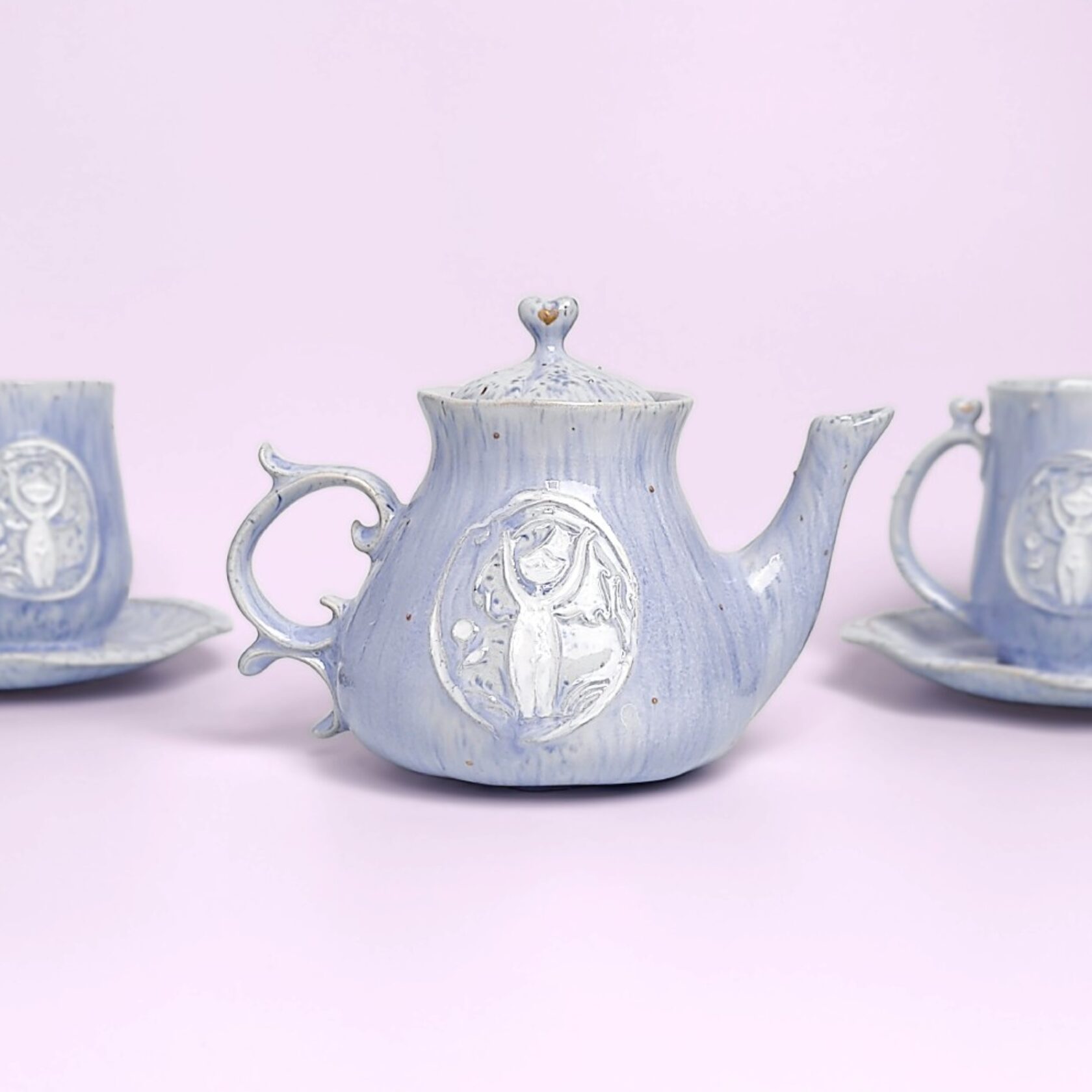 delicate blue handmade tea set — teapot, cups and saucers with carved forest fairy medallions