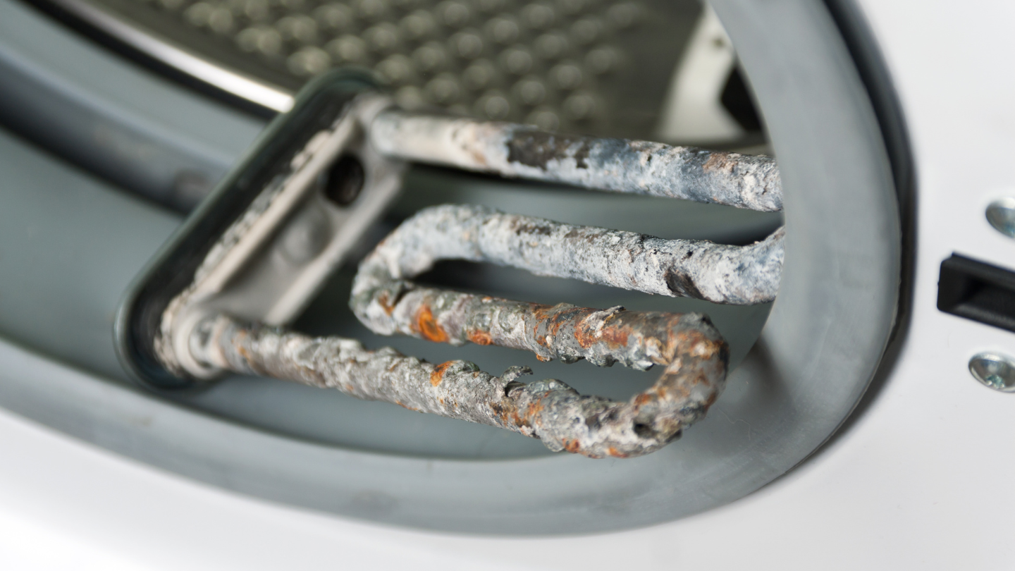 The image shows a heating element covered in limescale buildup, illustrating the negative effects of hard water in Cyprus