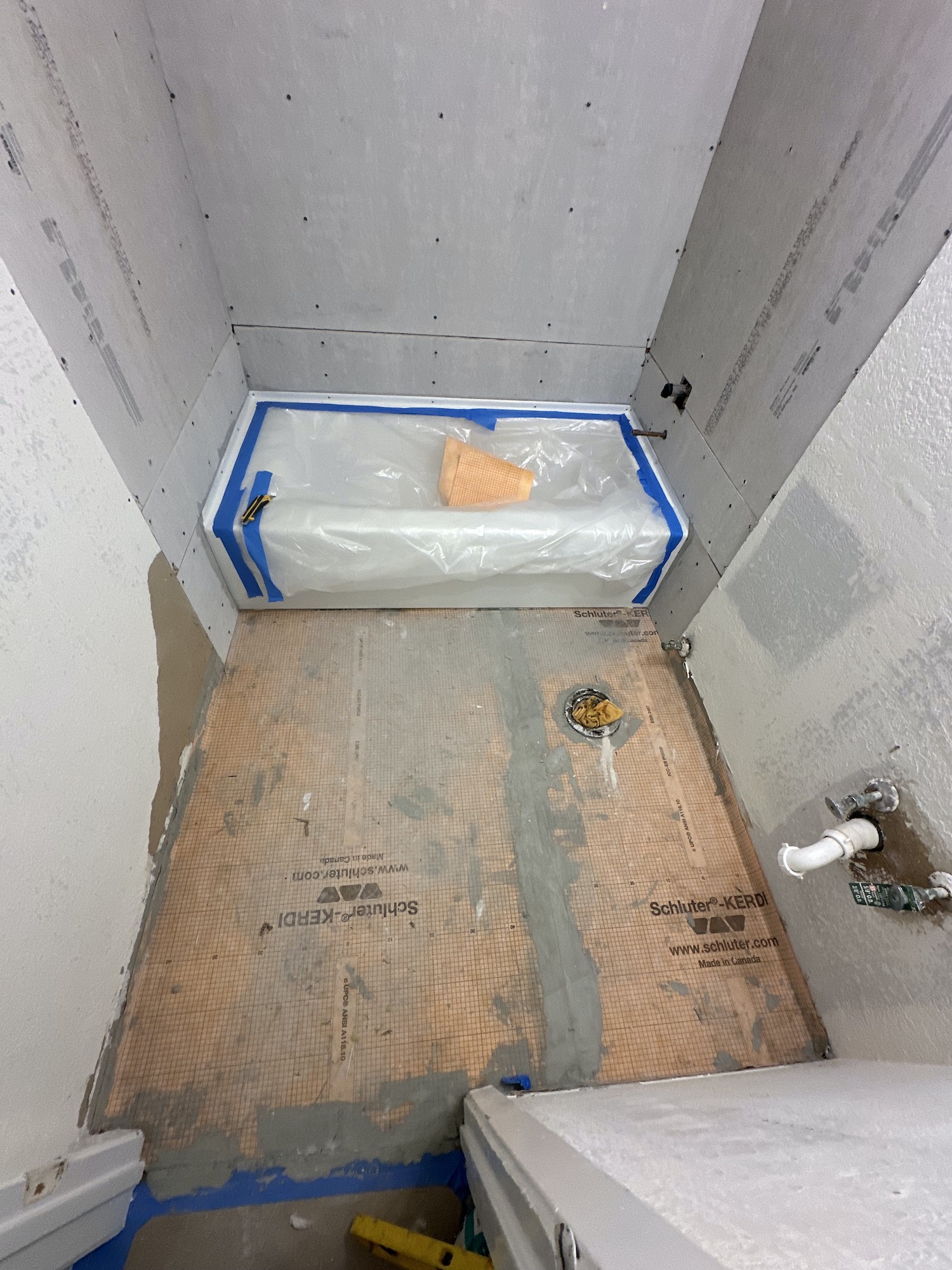 New bathtub protected during bathroom wall and floor preparation