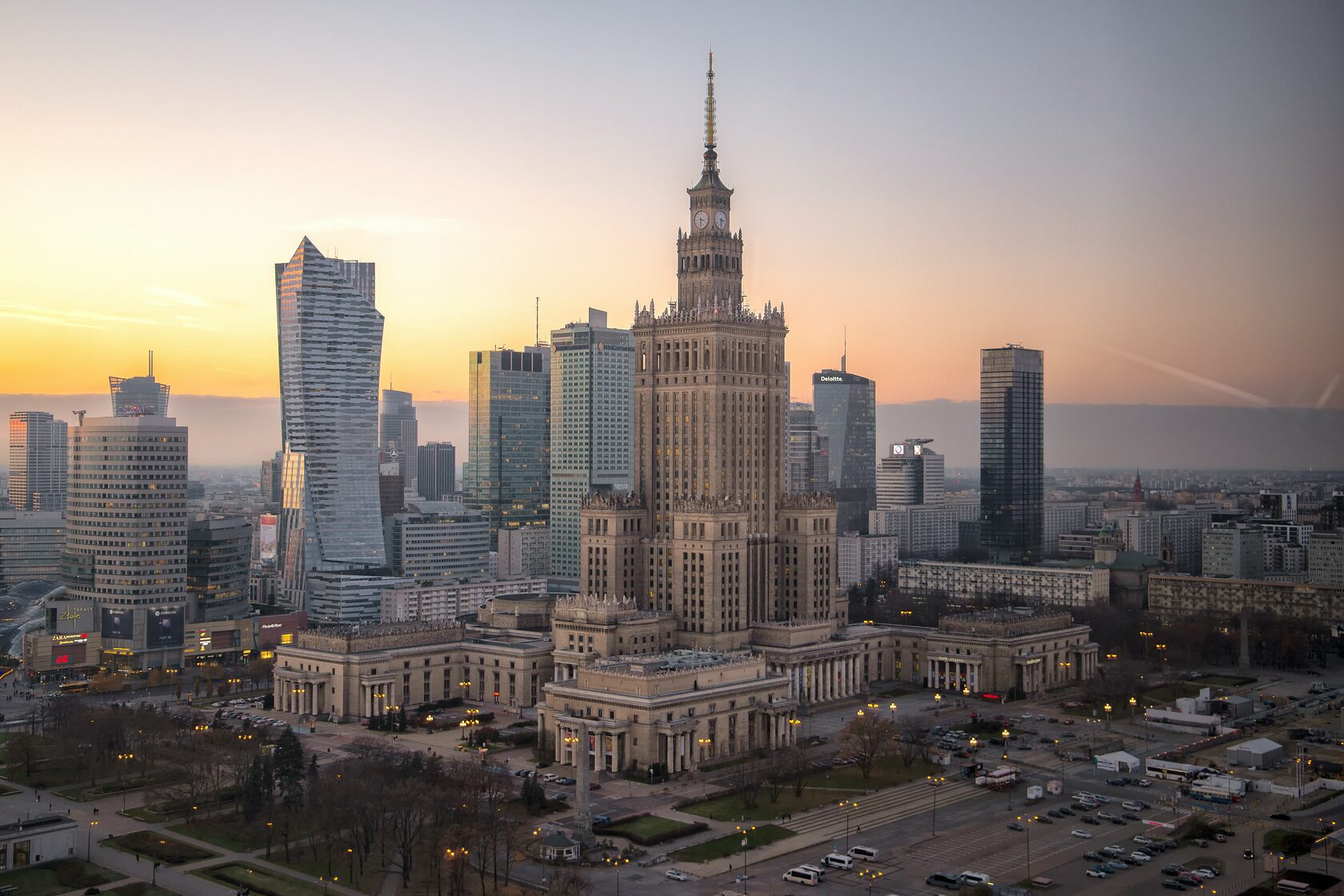 Warsaw at sunset with a tall building in the background