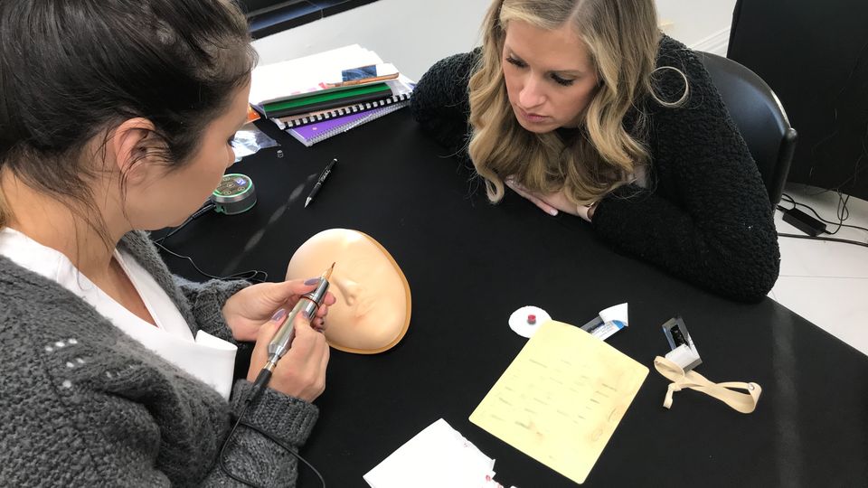Students practicing on a training face during class
