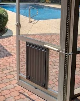 Heavy-duty pet screen door panel at the base of a door