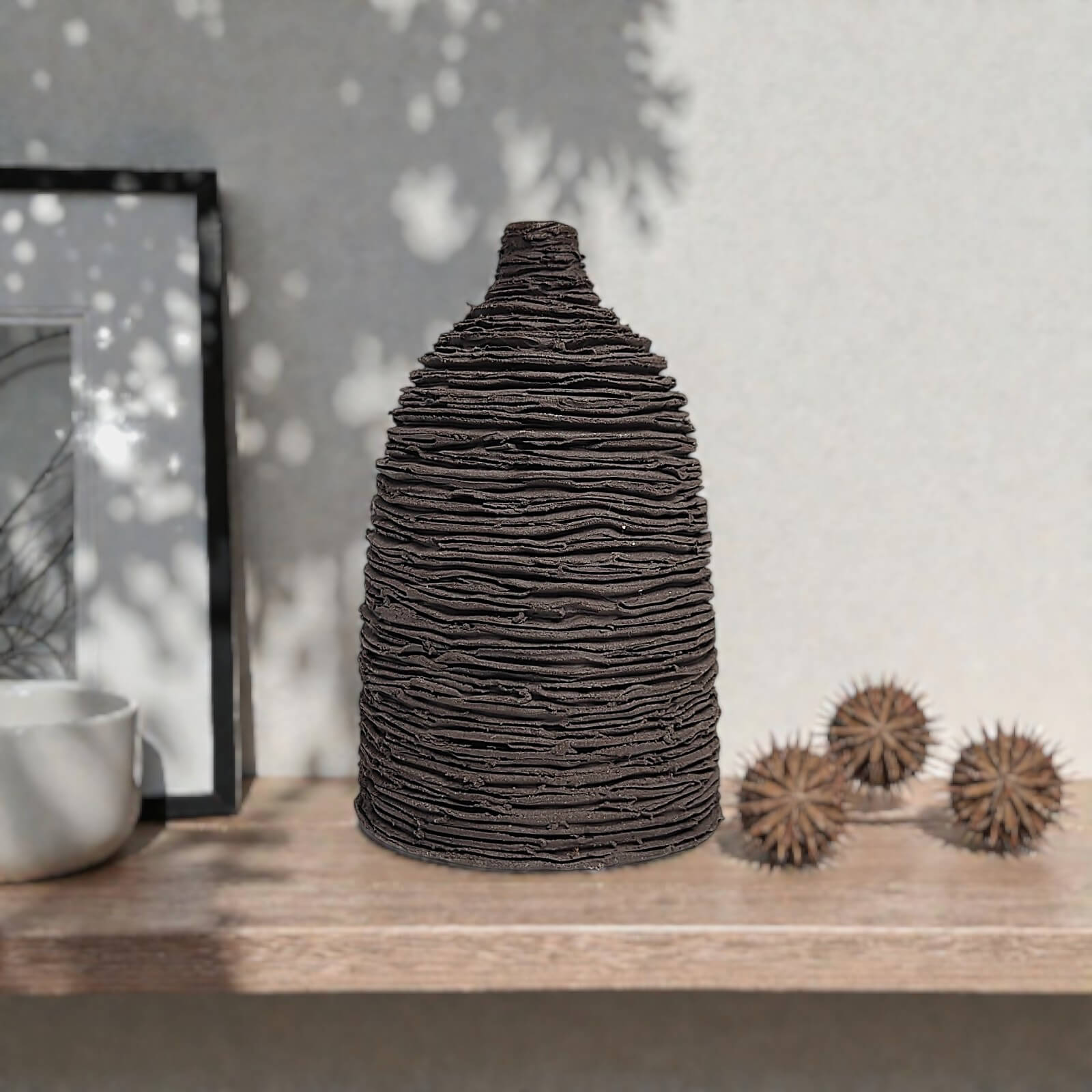 unique handmade black ceramic bud vase featuring a sculptural layered texture, minimalist modern decor for a single flower