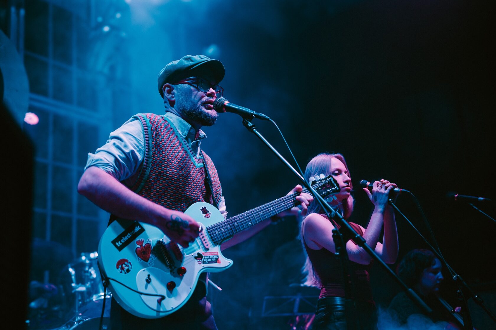 Lead singer and guitarist under blue stage lights