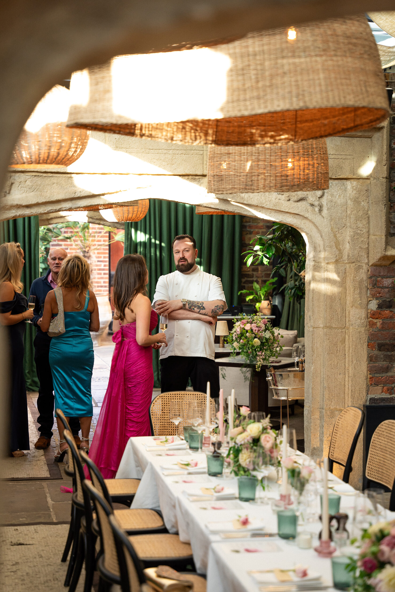 Guests beside a set dining table at an indoor celebration