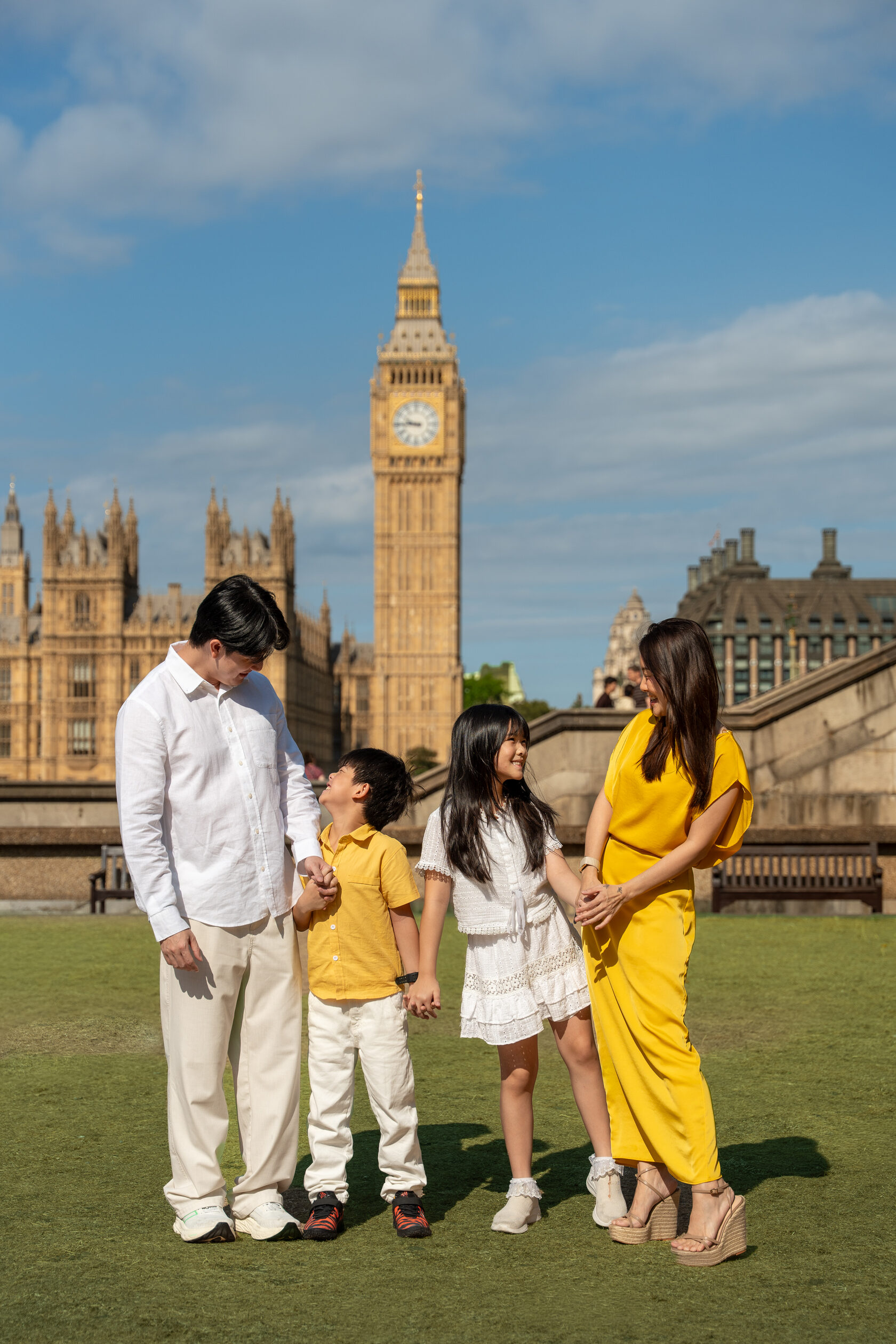 Family gathered on the grass with Big Ben behind them