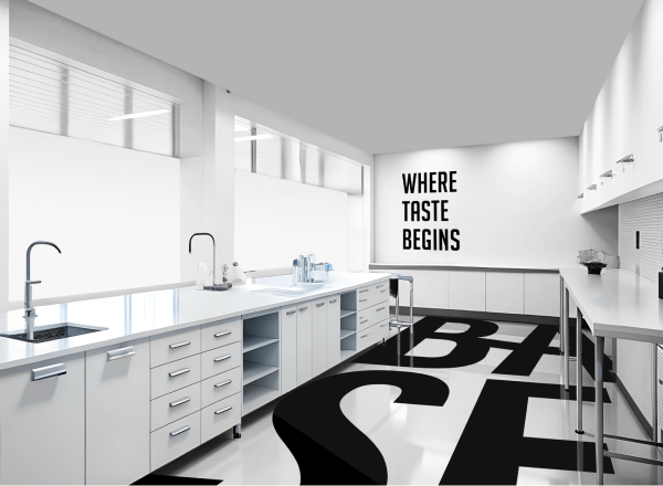 The Base Beverage laboratory interior with white worktops and the company wordmark on the wall