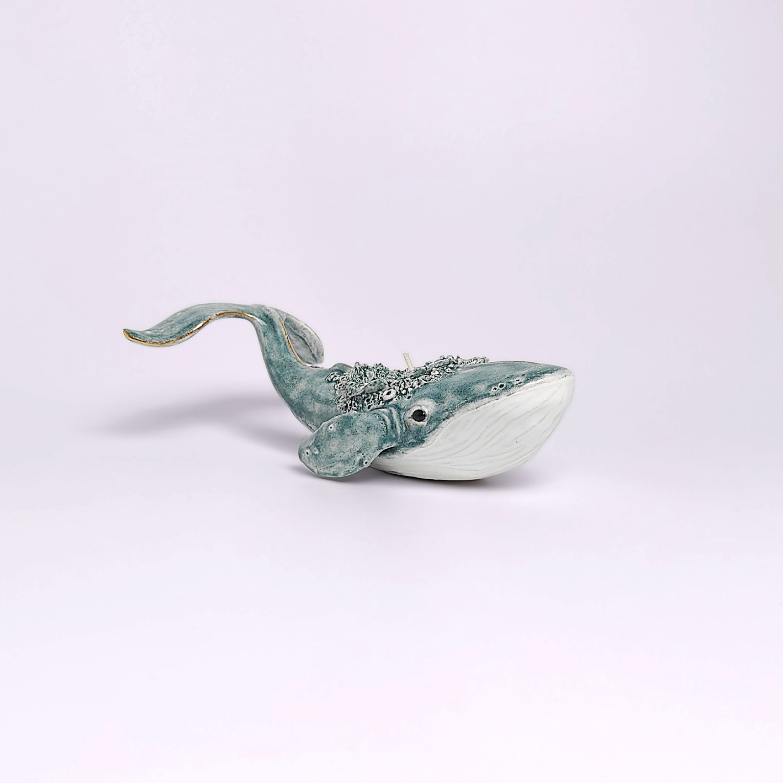 Unique handmade lagoon-colored ceramic whale with detailed sculptural texture and a built-in candle, inspired by ocean forms