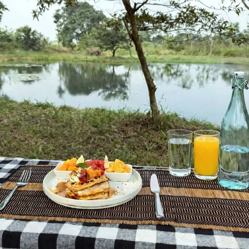 Outdoor breakfast with fruit, juice, and water beside the pond at Vonfidel Ranch