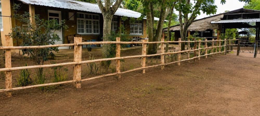 Rustic timber fence and ranch house at Vonfidel Ranch in eastern Sri Lanka