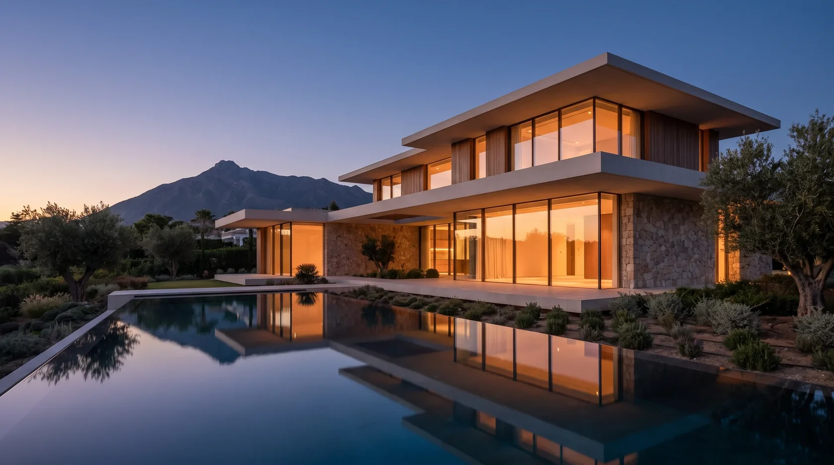 Contemporary villa with floor-to-ceiling glass and infinity pool at dusk in Nueva Andalucía