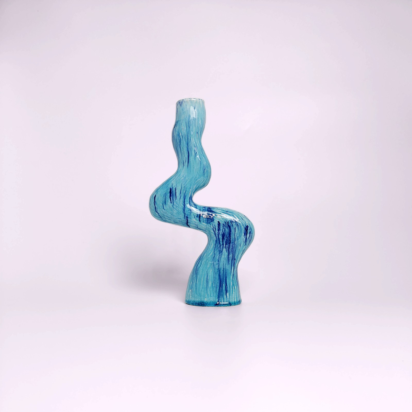 unique handmade ceramic candle holder for a single candle, featuring an organic wavy shape and blue glaze with watercolor-like drips