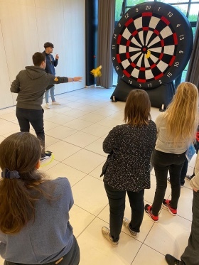 photo pris d'un participant en train de jeter ses fléchettes sur une cible géante durant l'épreuve des fléchettes géantes pour l'activité olympiade organisé par level up event à l'occasion d'un team building à Paris